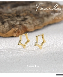 Detailed view of polished gold star hoop earrings on an artistic textured background
