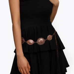 Détail de chaîne de taille bohème en bronze avec médaillons soleil sur robe noire