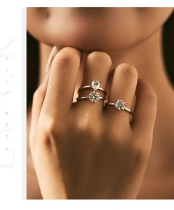 Detailed view of sterling silver rings featuring teardrop, round, and square cut moissanite