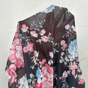 Gros plan sur un tissu en maille noire légère avec imprimés roses et haute transparence