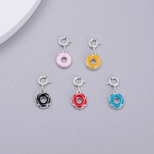 Macro view of five colorful enamel donut charms with silver spring clasps for jewelry DIY