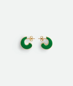 Detailed macro view of C-shaped 18K gold earrings with green enamel inlay texture