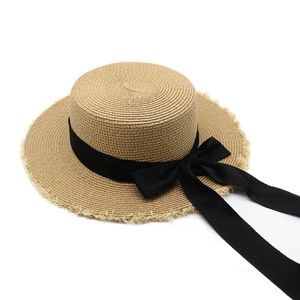 Flat top raffia boater hat with frayed edges and a large black ribbon bow for women