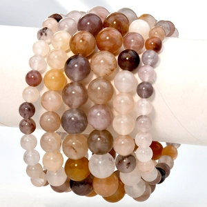 Elegante Naturstein-Perlenarmbänder in Violett- und Erdtönen auf weißem Displayständer