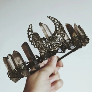 Macro shot of natural crystal stones and metal moon charm on a handmade crown headband