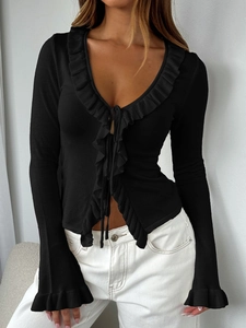 Detail of black knit cardigan featuring ruffle trim edges and tie-front closure design
