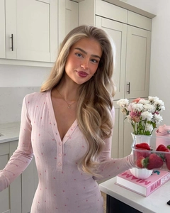 Dettaglio di tutina a fiori rosa con scollo a V in un ambiente cucina accogliente