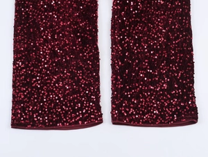 Close-up detail of wine red sequins and faux fur trim texture on high-quality fabric