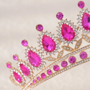Macro detail of royal gold tiara featuring large pear-cut rose pink crystals and diamonds