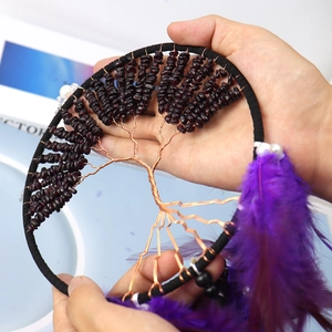 Close-up of tree of life dreamcatcher with purple crystal stones and bronze wire detailing