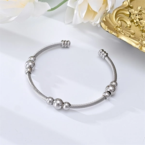 Detailed view of stainless steel twisted wire cable bracelet with polished round beads