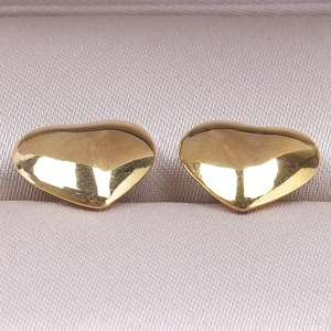 Macro shot of polished gold heart stud earrings showing smooth 304 stainless steel texture