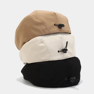 Detail of canvas beret hats in khaki, cream and black with adjustable back straps