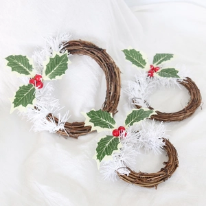 Détail de trois couronnes de Noël en rotin tressé avec baies rouges et aiguilles enneigées