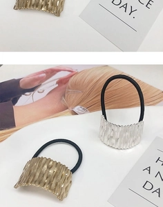 Detailed macro view of gold and silver metallic textured hair rings with elastic bands