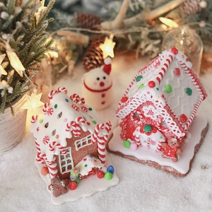 Close-up of lighted clay gingerbread house with intricate frosting and miniature details