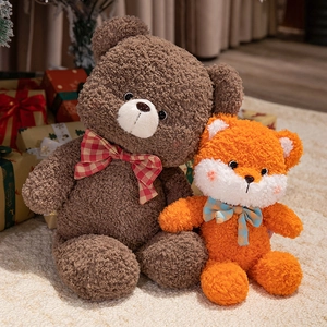 Cute plush bear and fox dolls with plaid bows on soft white carpet for holiday gifting