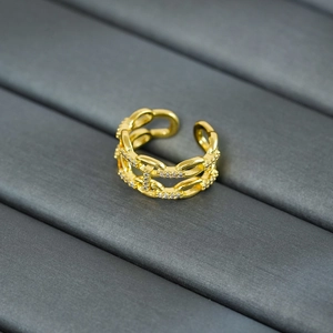 Detail of gold chain link ring with micro-pave cubic zirconia on dark fabric