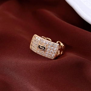 Macro shot of gold rectangle chain ring with pavé zircons on dark red silk fabric