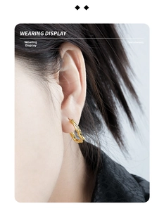 Close-up of elegant gold U-shaped wavy hoop earring with inlaid zircon on ear