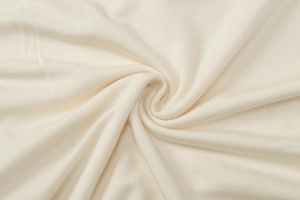 Macro primo piano del tessuto a maglia beige che mostra pieghe e consistenza morbida