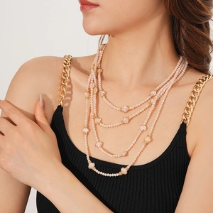 Vue détaillée d'un collier de perles roses multicouches porté par un mannequin