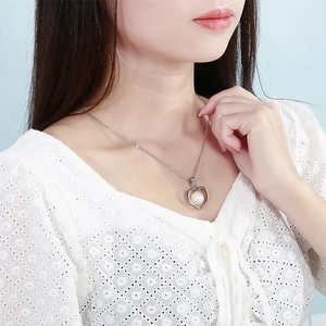 Minimalist silver stainless steel heart necklace with white pearl on a model