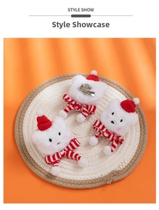 Detailed view of three plush Christmas cat pins with red hats and striped scarves on a mat