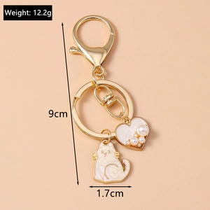 Detailed view of cat and heart keychain with pearls and dimensions marked 9cm