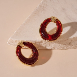 Detailed macro shot of vintage oval resin earrings with gold edges on stone