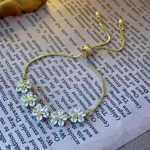 Detail of adjustable gold star flower bracelet with sparkling cubic zirconia on retro background