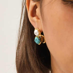 French style stainless steel earrings with pearl and tiger eye stone shown on a model