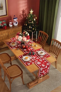 Macro detail of red Christmas table runner set with snowflakes, ornaments and tassels