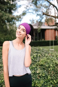 Primer plano de un modelo con una cinta deportiva morada flexible en un entorno natural