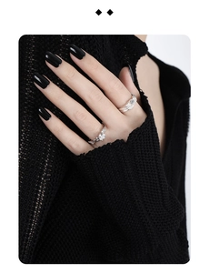 Detailed view of silver rings with sparkling zircons on irregular textured metal bands