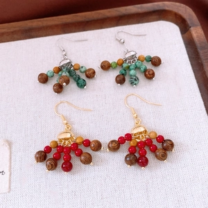 Détail de boucles d'oreilles bohèmes avec perles en bois et glands colorés