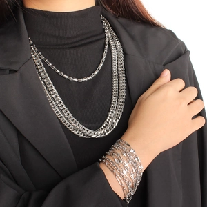 Multi-layer silver stainless steel necklace and bracelet set worn by a model
