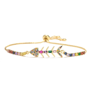 Macro detail of gold-plated fishbone bracelet with vibrant multicolor zircon crystals