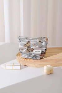 Close-up of vintage butterfly makeup bag with silver fabric and premium metal zipper