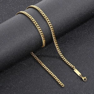 Détail d'un collier chaîne cubaine dorée avec fermoir mousqueton et plaque d'extension
