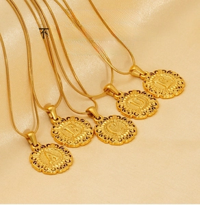 Gros plan de colliers en acier doré avec pendentifs lettres et chaîne serpent
