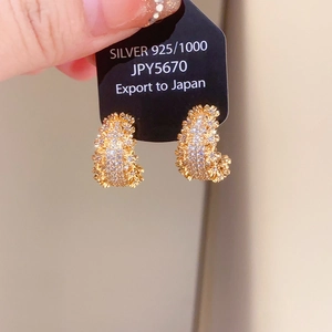 Gros plan sur les boucles d'oreilles créoles C en argent 925 plaqué or avec cristaux