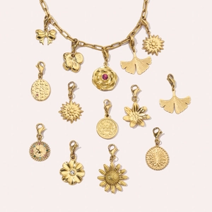 Detailansicht der goldenen Edelstahlkette mit auswechselbaren Blumen- und Schleifenanhängern