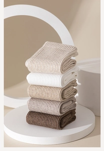 Five pairs of rib-knit cotton socks in beige and brown earth tones neatly stacked