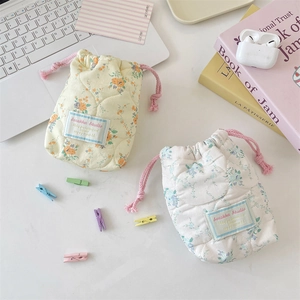 Close-up of quilted floral drawstring bags for cameras with soft cotton padding texture