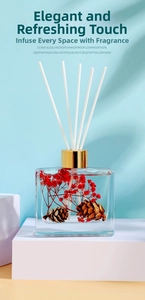 Detail of 100ml reed diffuser with red dried flowers and pine cones in a glass bottle