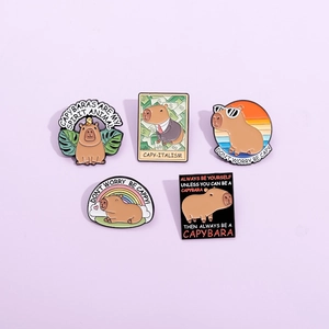 Set of five cute cartoon capybara enamel pins featuring funny puns and colorful designs