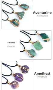 Detail of natural raw crystal pendants in amethyst and fluorite with gold edges