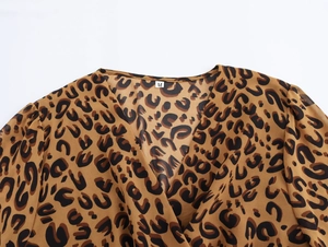 Detail of V-neck leopard print dress showing M size tag and fabric texture