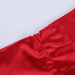 Close-up of red satin fabric texture and hidden zipper detail on the formal dress